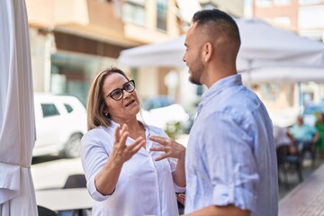 Man and woman mother and daugther standing together speaking at street