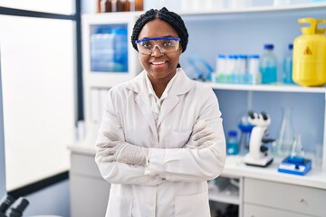 African american woman scientist smiling confident standing with arms crossed gesture at laboratory