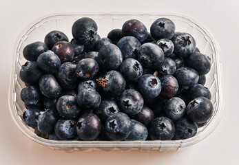  Delicious group of blueberries on plastic box over isolated white background