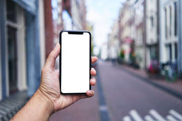 Man holding smartphone showing white blank screen at amsterdam