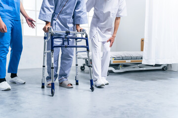 歩行器を使ってリハビリする患者とケアスタッフ