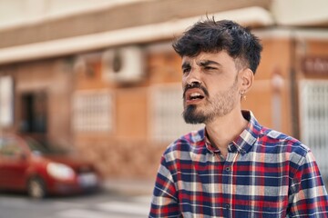 Obraz premium Young hispanic man angry screaming at street