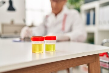 Middle age man wearing doctor uniform write on clipboard at clinic