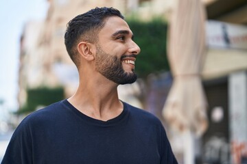 Young arab man smiling confident looking to the side at street