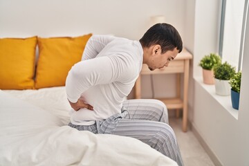 Fototapeta premium Young man suffering for backache at bedroom