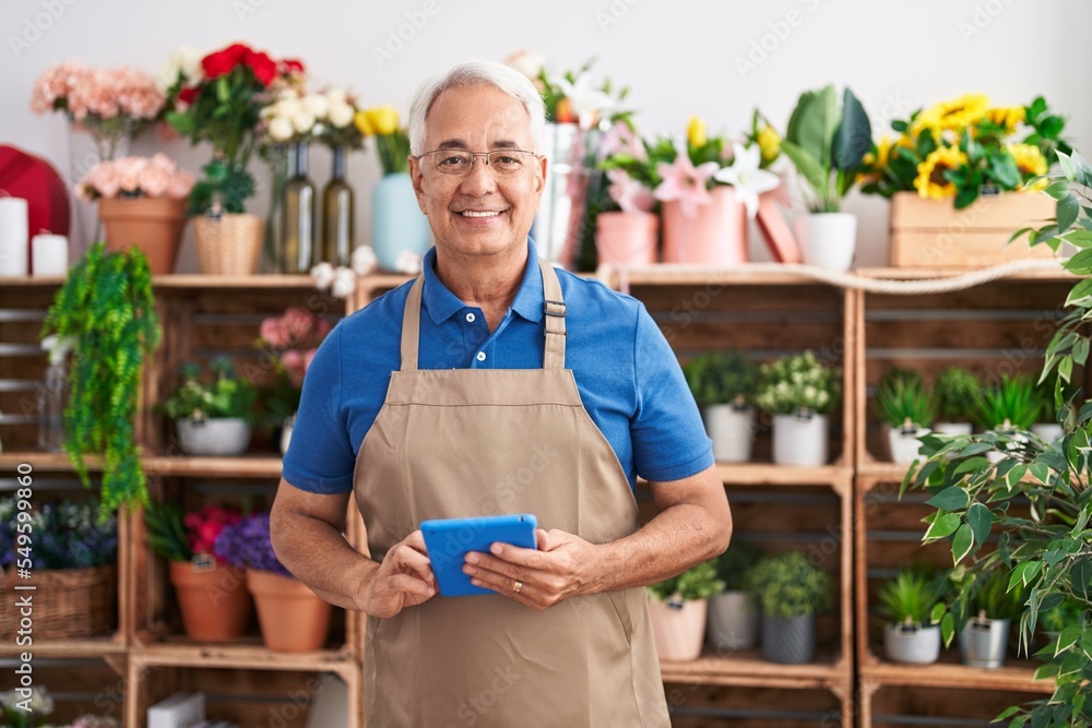 Canvas Prints Middle age grey-haired man florist smiling confident using touchpad at florist