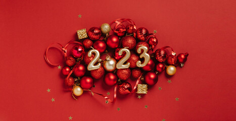 Date 2023 red background of Christmas toys, balls sparkles. Beautiful festive New Year's mockup