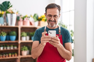 Middle age man florist smiling confident using smartphone at florist