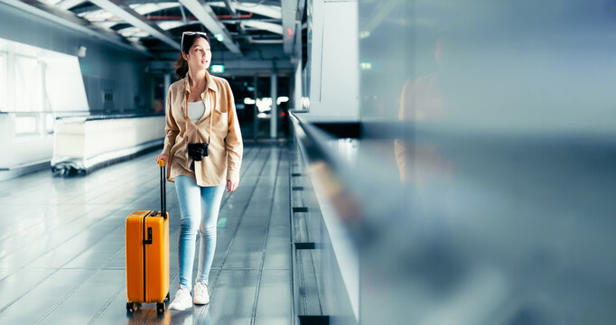 International airport terminal. Asian beautiful woman with luggage and walking in airport