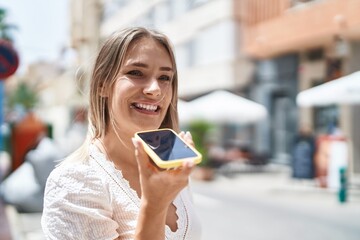 Young caucasian woman smiling confident talking on the smartphone at street