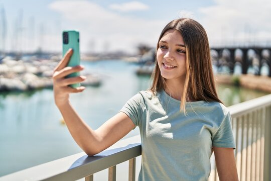 Adorable girl smiling confident making selfie by the smartphone at seaside
