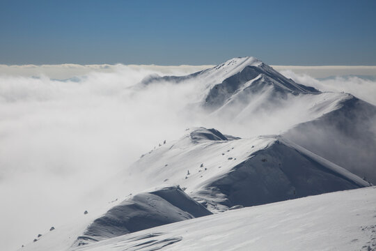 Snowy mountain against the background of a large massive Marmaros mountain range
