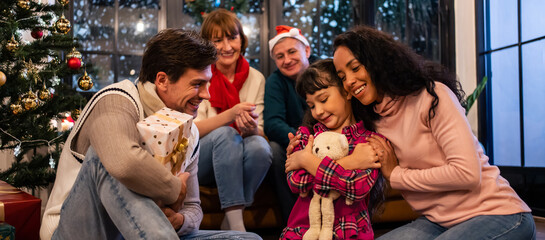 Caucasian family exchanging presents during Christmas party at home. 