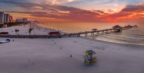 Sunset at Clearwater beach with Pier 60 fishing pier, white sand beach dramatic colorful sky