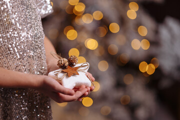 Close-up of children's hands holding a Christmas decoration.