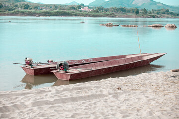 Obraz premium Small fishing boat with fishing net and equipment. A long-tailed boat stranded on the beach for repairs at HuayLa Beach.