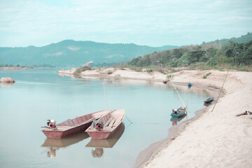 Small fishing boat with fishing net and equipment. A long-tailed boat stranded on the beach for repairs at HuayLa Beach.