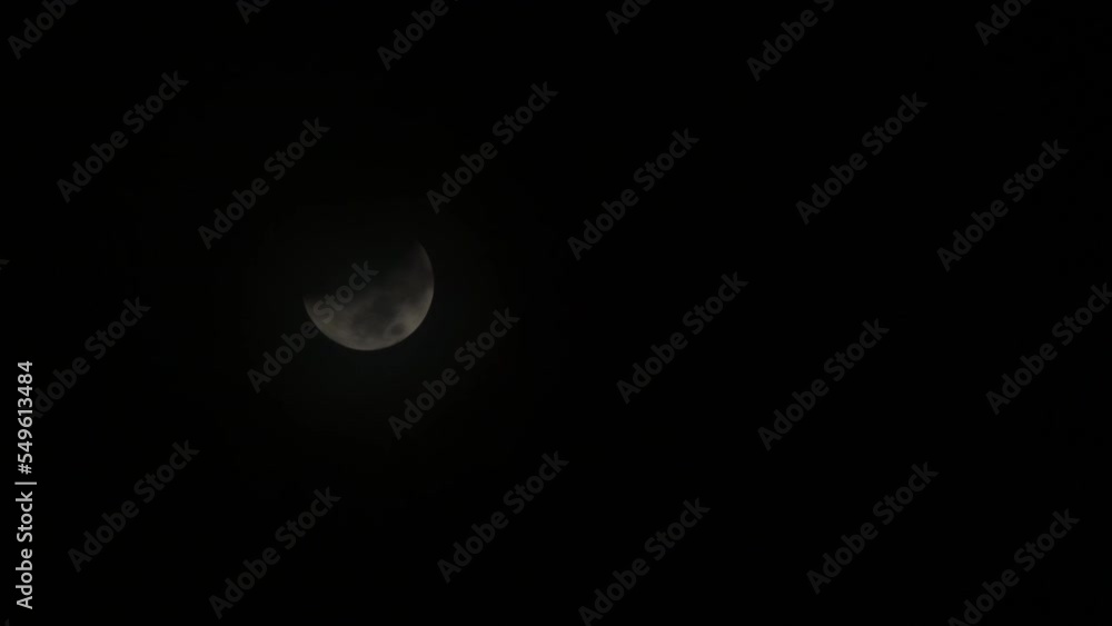 Poster partial lunar eclipse with clouds rolling over it - 11-08-2022 - moon in half shadow
