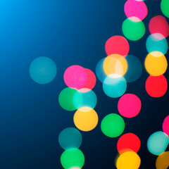 Blurred bokeh colorful lights lanterns, holiday new year lighting on black background Christmas winter glitter shiny light bokeh in rainbow colors.