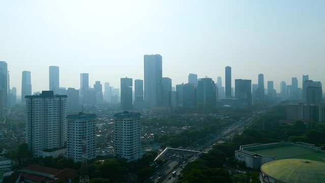 Drone view of highway with misty Jakarta cityscape