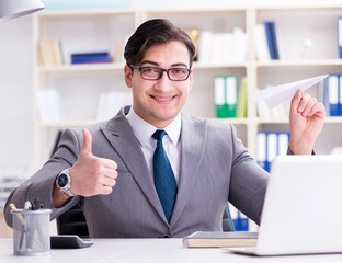 Businessman with paper airplane in office