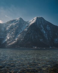 Landscape of Snowy Mountains Alps by lake in Hallstatt, Austria with blue sky