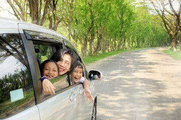 Mother and children travel by car while passing park