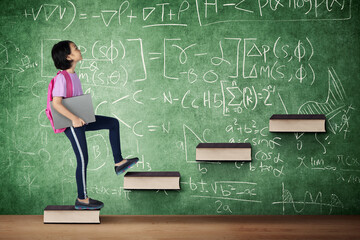 Schoolgirl climbing book stair in the class