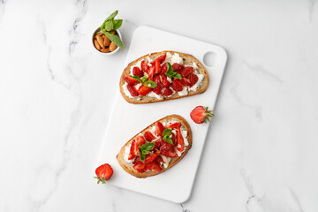 Sweet Toast with strawberry, cottage cheese ricotta cheese, honey, almond and mint. Sandwich, Bruschetta, snack, appetizers with strawberry. Copy space, text, top view.