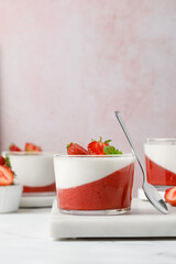 Strawberry panna cotta creamy dessert - panna cotta with strawberry in a glass jars decorated with fresh berries and mint. Traditional Italian sweet dessert.