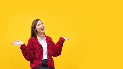Fototapeta na wymiar Women are smile and holding something in both hands with empty space on isolated yellow background