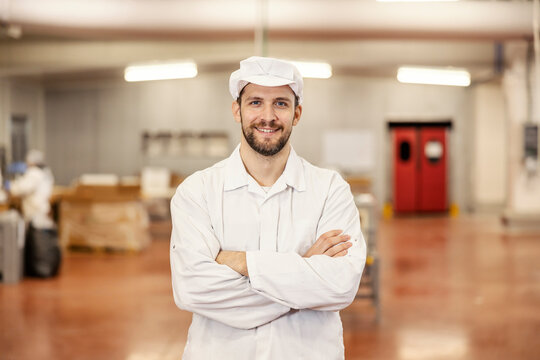 Portrait of a confident meat factory worker smiling at the camera.