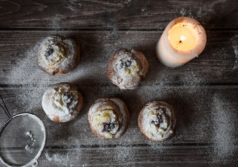 muffins with custard, berries and powdered sugar on a wooden table