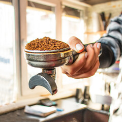 barista hand holding coffee holder with ground coffee,portafilter,selective focus,  professional, 