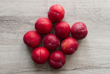 Fresh plums isolated on wooden table background