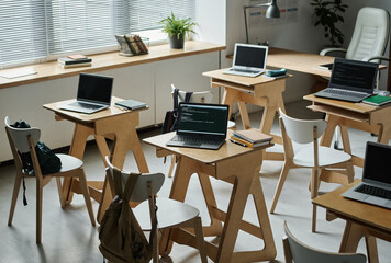 Modern classroom for IT lesson with wooden desks with computers