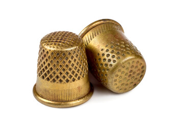 Two antique copper thimbles on a white background. Old thimbles close-up. A selective focus. - obrazy, fototapety, plakaty