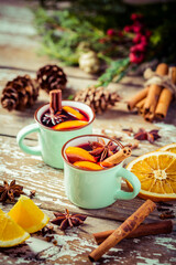 Mulled wine in rustic mugs with spices and citrus fruit