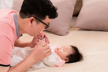 Asian father sing or talk with adorable daughter on bed, close up dad eye contact with healthy...