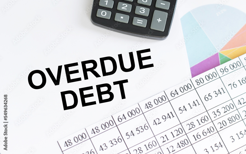 Poster overdue debt text on a paper sheet with chart,color paper and calculator