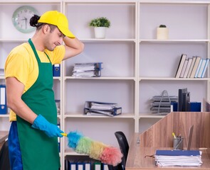 Young male contractor cleaning the office