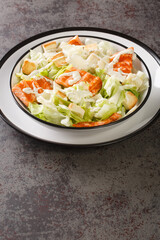 Salmon Caesar Salad it features easy homemade dressing, freshly baked croutons, parmesan and grilled salmon closeup on the plate on the table. Vertical