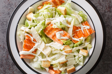 Plate with fresh caesar salad with Grilled Salmon, Croutons, Parmesan, Caesar Dressing closeup on...