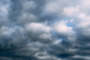 Fototapeta premium A dark blue cloudy sky. Cumulus clouds. Nature background. Bad weather forecast. Before a thunderstorm, hurricane or storm. The power and strength of nature. Air element. Wallpaper. Moving ciclone