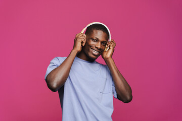Black young man smiling and listening music with headphones