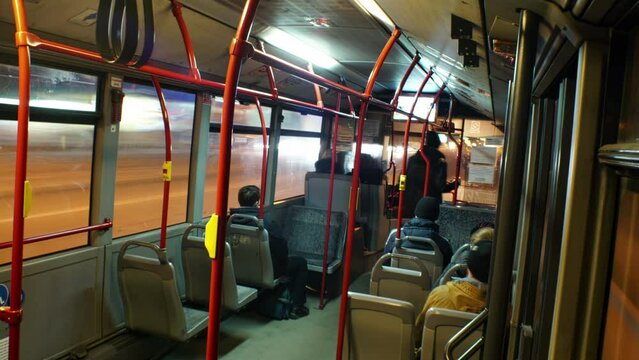 City Bus Interior with people entering and moving around in Motion Blur. Driving Night city Road.
