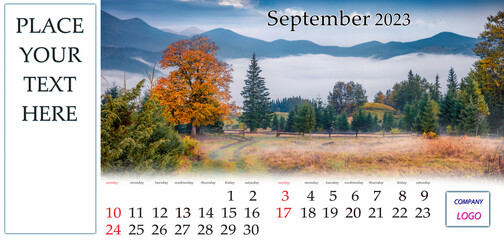September 2023. Desktop monthly calendar template with place logo and contact information. Set of calendars with amazing landscapes. Foggy autumn view of mountain valley with old country road.
