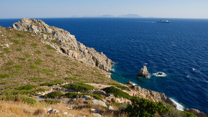 Aegean coast. Rocky and cliff seaside. Blue sky, dark blue sea and rocks. The focus is on the sea.
