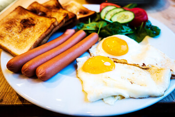 Three pieces of French toasts with seeds mix toppings for a sweet and healthy breakfast served in white plate and black coffee.