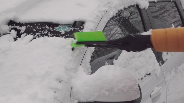 Driver cleans his car after snow. Preparing for winter driving